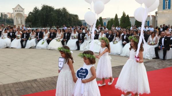Bridemades carry balloons as Lebanese Maronite Christian couples take part in a mass wedding at the Maronite Patriarchate in Bkerke on September 2, 2018. 
ANWAR AMRO / AFP