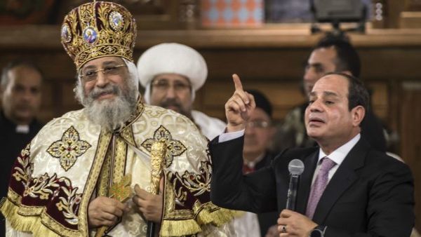 Egyptian President Abdel Fattah al-Sisi speaks near Coptic Pope Tawadros II (L) during a Christmas Eve mass. (AFP/Khaled Desouki)