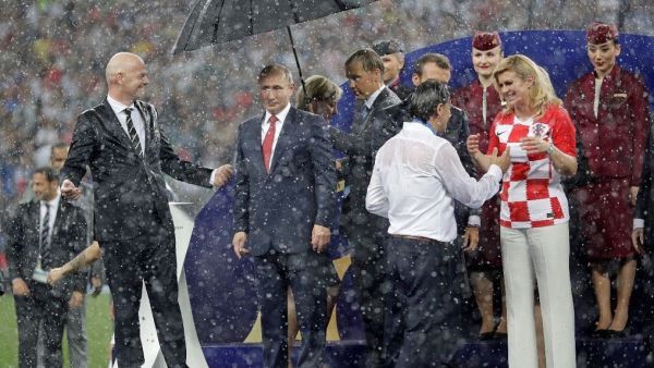 The Croatian and French presidents while getting drenched in the heavy rain during the World Cup final ceremony while Russia's Putin is the only one to get an umbrella. (Twitter)