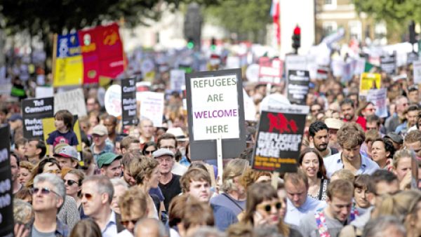Demonstrators hold placards as they take part in a pro-refugee rally in central London. (AFP/FilePhoto)