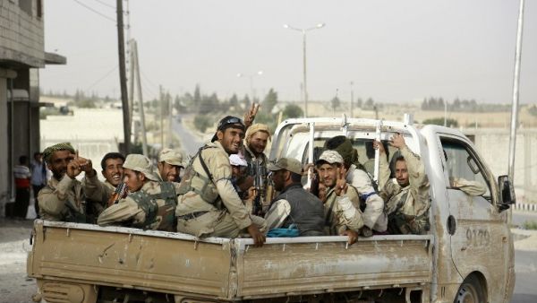 Fighters from Syria's Manbij military council sit on June 15, 2016 in the back of a pickup truck on the outskirts of the northern Syrian town of Manbij. (AFP/Souleiman)