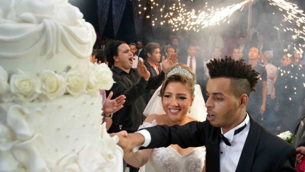 Mai and Oka cut their huge and delicious wedding cake. (Alwafd.org)