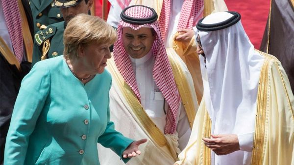 A handout picture provided by the Saudi Royal Palace shows German Chancellor Angela Merkel (L) chatting with Saudi Arabia’s King Salman (R) during a welcome ceremony in Riyadh on April 30, 2017. (AFP/ Bandar Al-Jaloud)