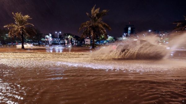 People ride cars on the flooded main road of the Daeya area of Kuwait city late on November 14, 2018. (Yasser Al-Zayyat / AFP)