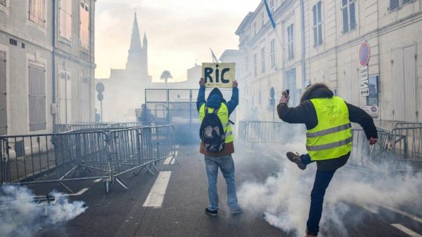 Protesters face riot police on January 5, 2019 in La Rochelle during a demonstration called by the yellow vests (gilets jaunes) movement. (AFP)