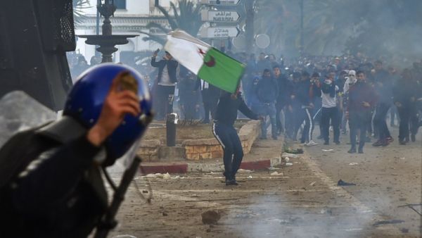A member of the Algerian security forces holds a rock in his hand as riot forces repsond to protesters gathering in the capital Algiers on March 1, 2019. (AFP)