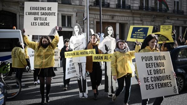 Women's rights activists hold signs as they take part in a demonstration organized by Amnesty International outside the Saudi Arabia embassy in Paris, on March 8, 2019 during International Women's Day. (AFP)
