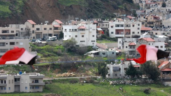 Syrian national flags are flown in the Syrian town Ain al-Tineh across from Majdal Shams in the Israeli-annexed Golan Heights on March 26, 2019. (Louai Beshara / AFP)