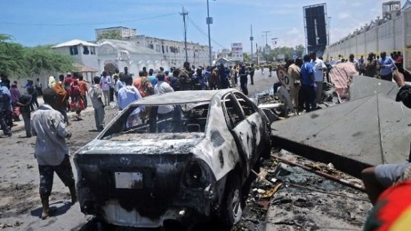 People stand at the site of a car bomb near a restaurant near the Somali ministry of internal security in Mogadishu on April 5, 2017. (AFP Photo)