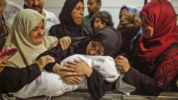 The body of a Palestinian baby who died of tear gas inhalation during protests, according to Gaza's health ministry, is held by her mother at a Gaza City morgue on May 15, 2018 (AFP /MAHMUD HAMS)