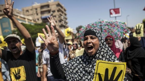 Supporters of ousted Egyptian president Mohamed Morsi raise posters with the four-finger symbol during a demonstration against the military-backed government in the Egyptian capital, Cairo.(AFP PHOTO/MAHMOUD KHALED)