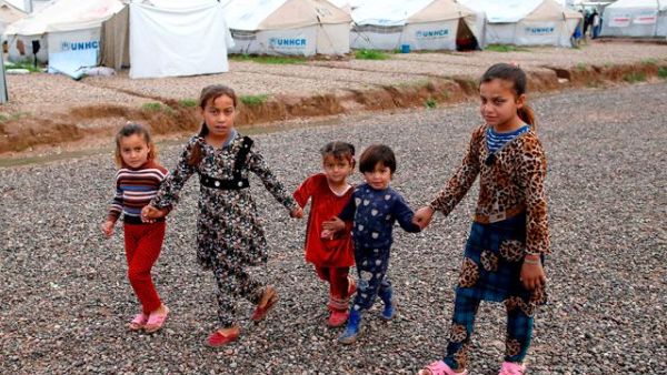 Displaced Iraqi children, who fled Mosul, walk at the Hasan Sham Camp, 30 kilometres east of Mosul, on Friday (AFP)