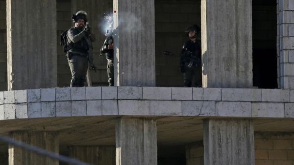An Israeli soldier fires a tear gas canister at Palestinian stone throwers following a raid in Ramallah. (AFP/ File)
