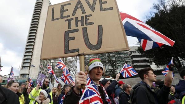Protesters hold up placards and Union flags as they attend a pro-Brexit demonstration. (AFP/ File)