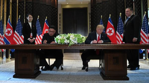 North Korea's leader Kim Jong-un and US President Donald Trump sign documents, June 12, 2018. (AFP/ File)