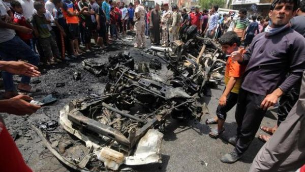 Iraqis look at the damage following a car bomb attack in Sadr City. (AFP/File)