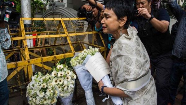 A woman leaves a floral arrangement on a road block leading to a cafe in Dhaka that was the site of a bloody siege. (AFP/File)
