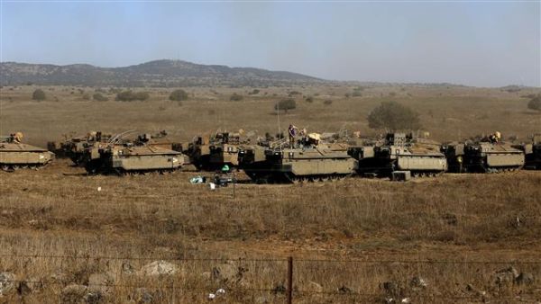 Israeli soldiers stand atop armored personnel carriers stationed in the Israeli-occupied Golan Heights. (AFP/File)