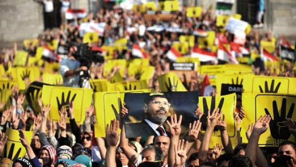 Supporters of the Egyptian Muslim Brotherhood gesture support for Morsi. (AFP/File)