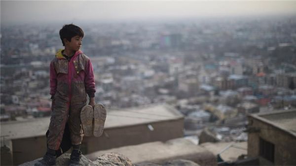 Afghan shoe-shine boy looks on from a hillside as he waits for customers in Kabul. (AFP/File)