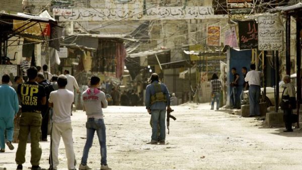 Fighters are seen along a street in the Ain al-Helweh Palestinian refugee camp on the outskirts of the southern Lebanese city of Sidon, on 12 March 2013, after one person was killed and several wounded in clashes that erupted in the camp. (AFP/Mahmoud Zayyat)