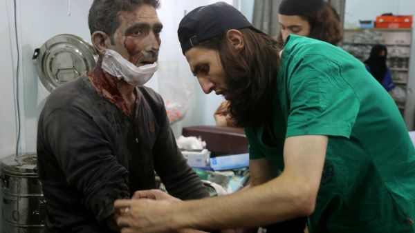 Syrian medics treat a man at a makeshift hospital in the Tariq al-Bab neighborhood. (AFP/File)