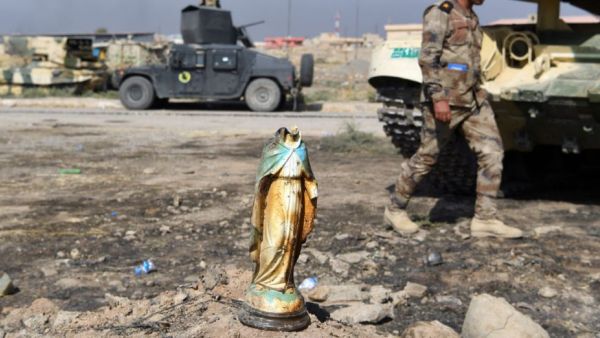 An Iraqi soldier walks past a broken statue of the virgin Mary. (AFP/File)
