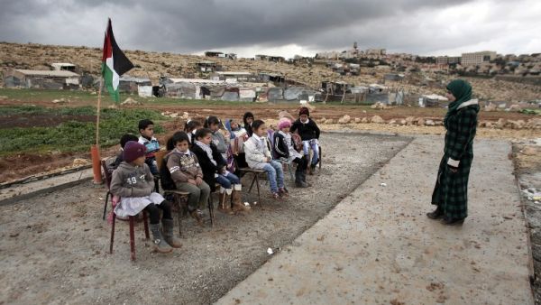 A Palestinian teacher leads a class of Palestinian Bedouin children from the Abu Anwar community. (AFP/File)