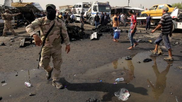Iraqi soldiers and civilians check the damage after a suicide bomber detonated an explosives-rigged vehicle in northern Baghdad's Sadr City, May 17, 2016. (AFP/Ahmad al Rubaye)