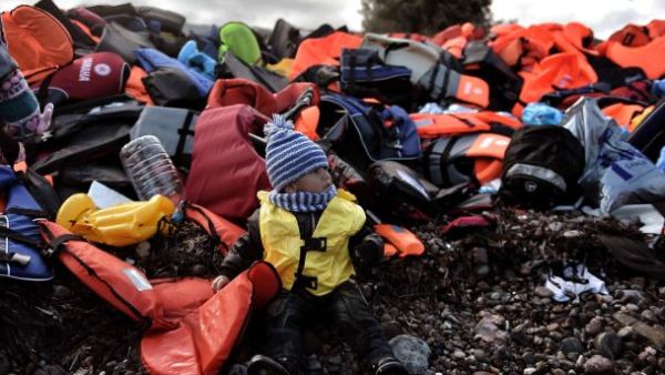 A child sits among life jackets on the Greek island of Lesbos after crossing the Aegean sea from Turkey with other refugees, October 25th 2015. (AFP/File)