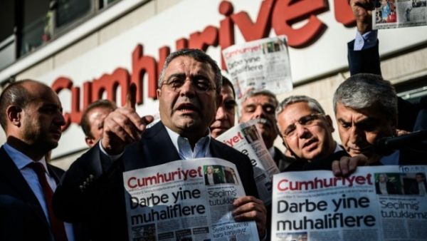 Main opposition Republic people's Party (CHP) member of parliament Sezgin Tanrikulu, left, gestures as politicians hold today's copy of Cumhuriyet newspaper in front of the newspaper's headquarters on October 31, 2016 in Istanbul. (AFP/Ozan Kose)