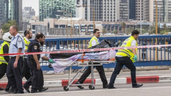 Volunteers remove the body of a Palestinian shot dead after carrying out a stabbing attack. (AFP/File)