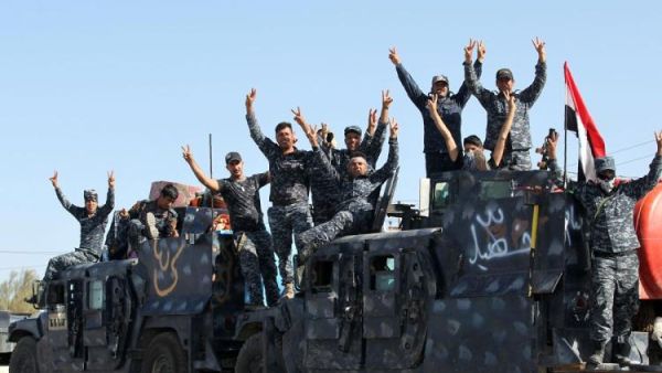 Iraqi forces gesture as they gather at the Qayyarah military base in preparation of an assault. (AFP/File)