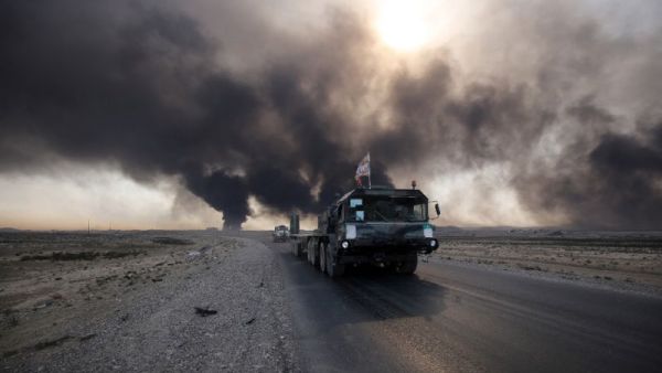 Iraqi army vehicle drives down a road east of Mosul, northern Iraq, on October 22, 2016, as displaced families flee areas of unrest during an operation to retake the city from Islamic State (IS) group jihadists. (AFP/Ahmad Al-Rubaye)