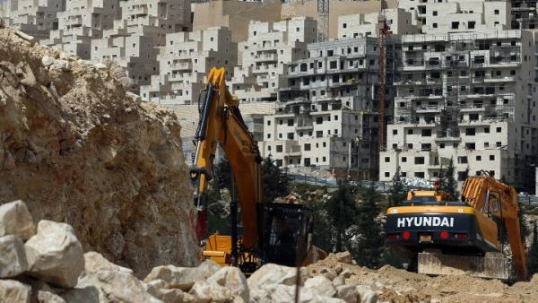 Israeli construction cranes and excavators at a building site in the Israeli settlement of Neve Yaakov, in the northern area of east Jerusalem on March 29, 2016. (AFP/Ahmad Gharabli)