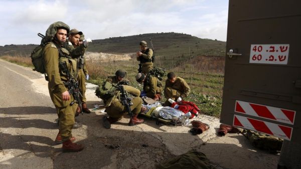 Israeli soldiers prepare on Tuesday to evacuate a comrade injured in a blast on the occupied Golan Heights near the village of Majdal Shams. (AFP/File)