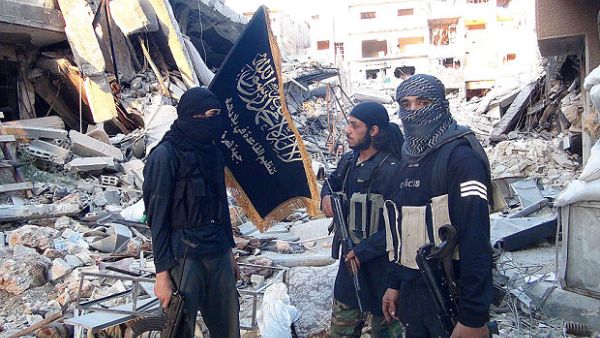 Al-Nusra Front fighters stand among destroyed buildings near the front line in Yarmouk. (AFP/File)