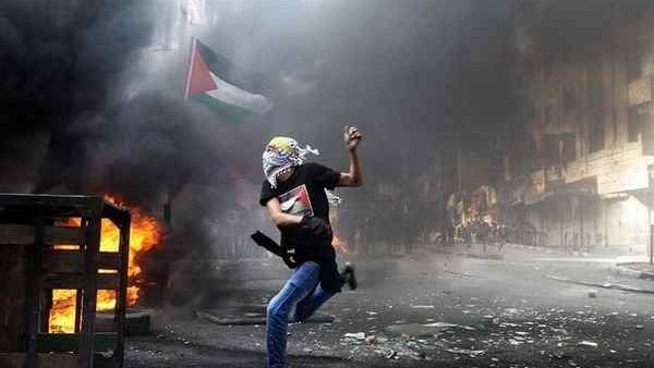 A masked Palestinian hurls rocks towards Israeli soldiers during clashes following the funeral of Mohammed Fares al-Jaabari on Oct. 10, 2015, in the center of the West Bank town of Hebron. (AFP/Hazem Bader)