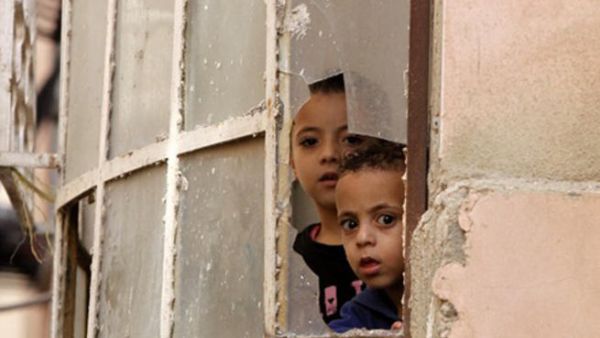 Palestinian children look through a window at Israeli soldiers conducting searches in the Palestinian al-Fawwar refugee camp, south of the West Bank city of Hebron. (AFP/File)