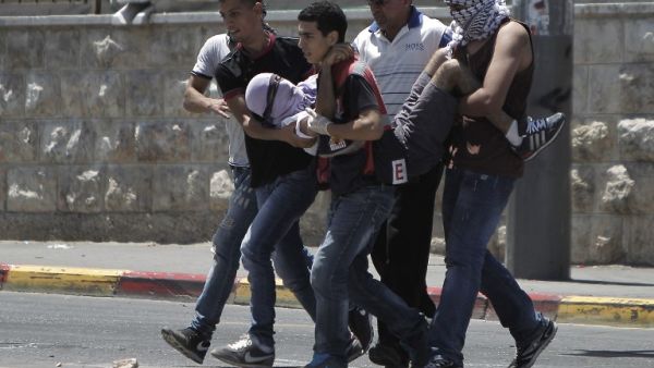 A Palestinian injured protester is carried by comrades during clashes with Israeli police in Shuafat neighborhood in Israeli-annexed Arab East Jerusalem on July 2, 2014. (AFP/File)