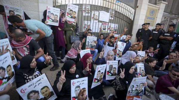 Palestinians hold posters against administrative detention and in support of Palestinian prisoners Bilal Kayed, Muhammad and Mahmud al-Balboul outside the United Nations building in the West Bank city of Ramallh, on August 22, 2016. (Twitter)