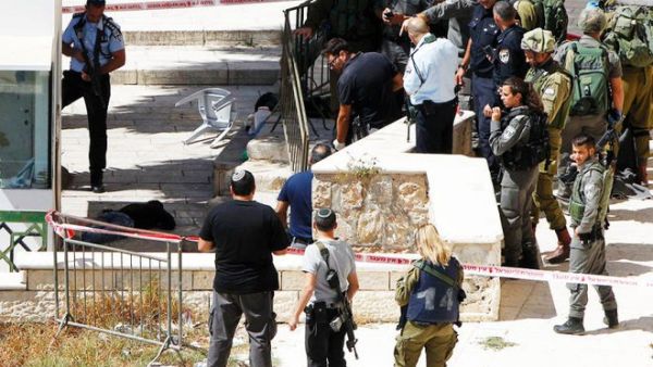 Israeli occupation forces gather around a wounded Palestinian near the Ibrahimi mosque in Hebron on Monday. (AFP/File) 