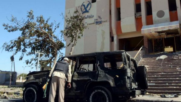 An Egyptian policeman inspects the wreckage after a car bomb blast kills three policemen in al-Tur, in the Sinai peninsula, on October 7, 2013. (AFP Photo/Mohamed el-Shahed)