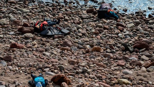Three bodies are washed up on a beach after authorities said at least 37 people were killed when their boat capsized in the Aegean Sea while trying to cross to Greece from Canakkale province, Turkey, Jan. 30, 2016. (AFP/Ozan Kose)