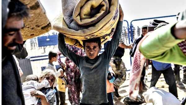 A young boy carries his bed cover. (AFP/Bulent Kilic)