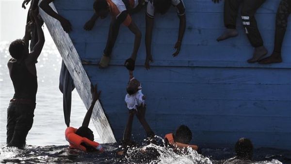 Refugees try to pull a child out of the water as they wait to be rescued by members of Proactiva Open Arms NGO in the Mediterranean sea, some 12 nautical miles north of Libya, on October 4, 2016. (AFP/File) Refugees try to pull a child out of the water as they wait to be rescued by members of Proactiva Open Arms NGO in the Mediterranean sea, some 12 nautical miles north of Libya, on October 4, 2016. (AFP/File)