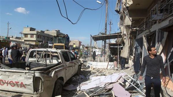 Iraqis stand at the site of a car bomb explosion in Sadr City in northern Baghdad. (AFP/File)