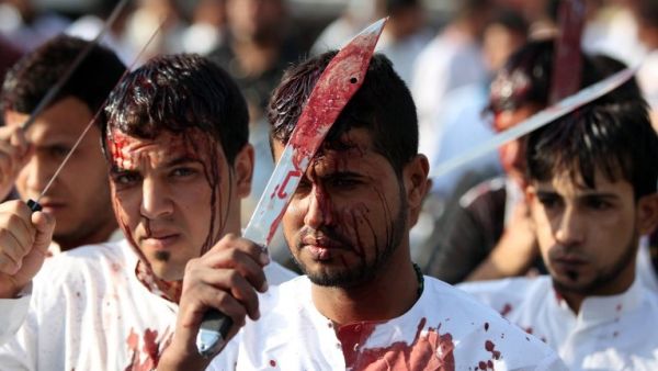 Iraqi men take part in a self-flagellation procession on the tenth day of the mourning period of Muharram, which marks the day of Ashura on October 24, 2015, in Baghdad's northern district of Kadhimiya. (AFP/Ahmad al-Rubaye)