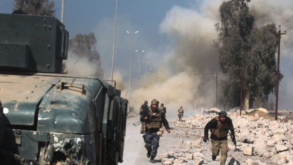 Smoke billows in the background as Iraqi forces advance on Mosul airport during an offensive. (AFP/File)