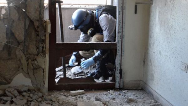 A United Nations weapons expert collects samples during an investigation into a 2013 suspected chemical weapons. (AFP/File)